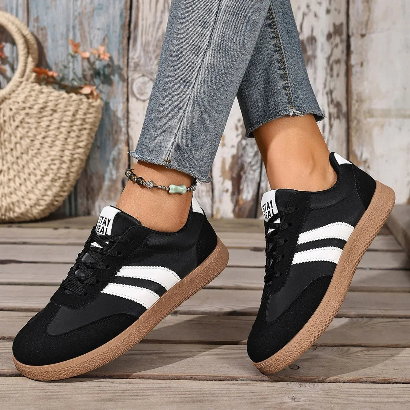 Black and white leather sneakers with gum soles and slip-on design for casual daily wear.