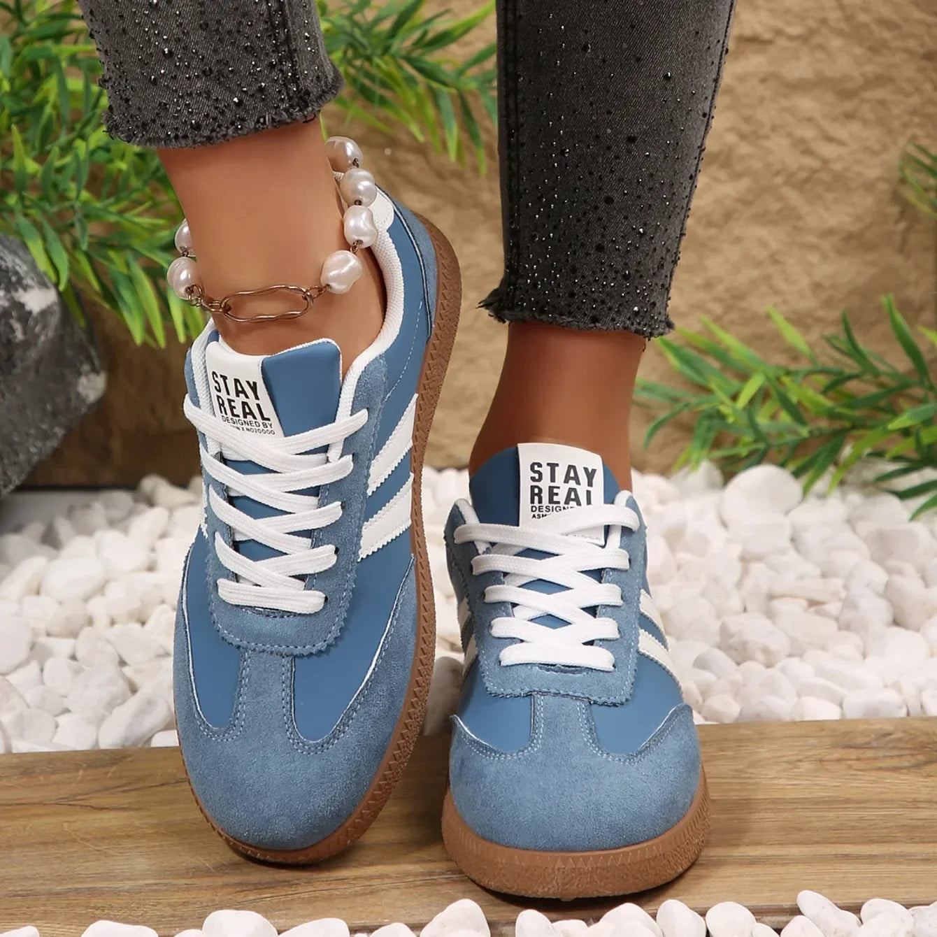 Blue leather slip-on sneakers with white stripes, white laces, and brown gum soles for casual daily wear.