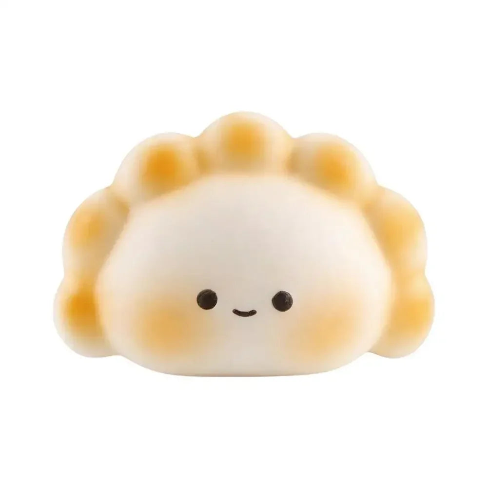 White and tan silicone dumpling squishy fidget toy with a smiling face for portable stress relief.