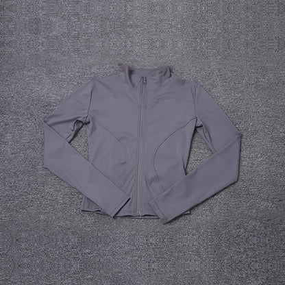 Grey fitted polyester sport jacket with long sleeves and zipper for yoga training.