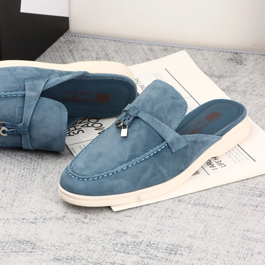 Blue suede slip-on shoes with a decorative buckle strap and white sole for casual daily wear.