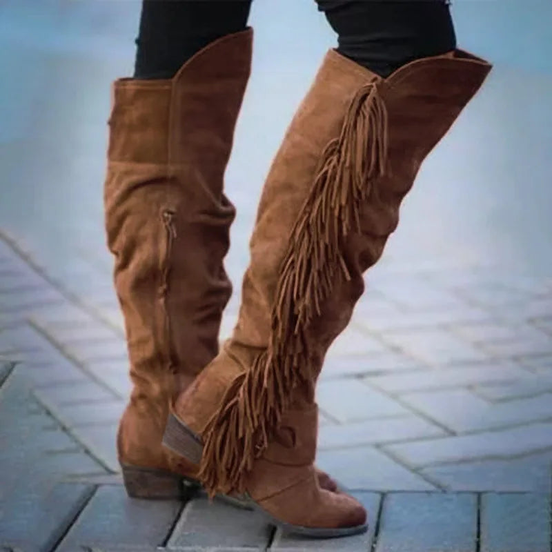 Brown suede over-the-knee boots with long fringe detailing and thick low heels.