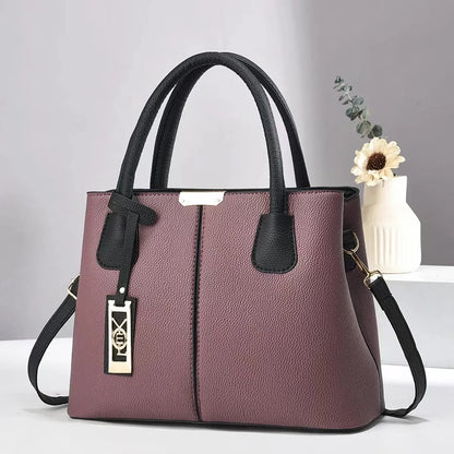 Mauve faux leather structured tote bag with black handles, zip closure, and gold hardware for everyday use.