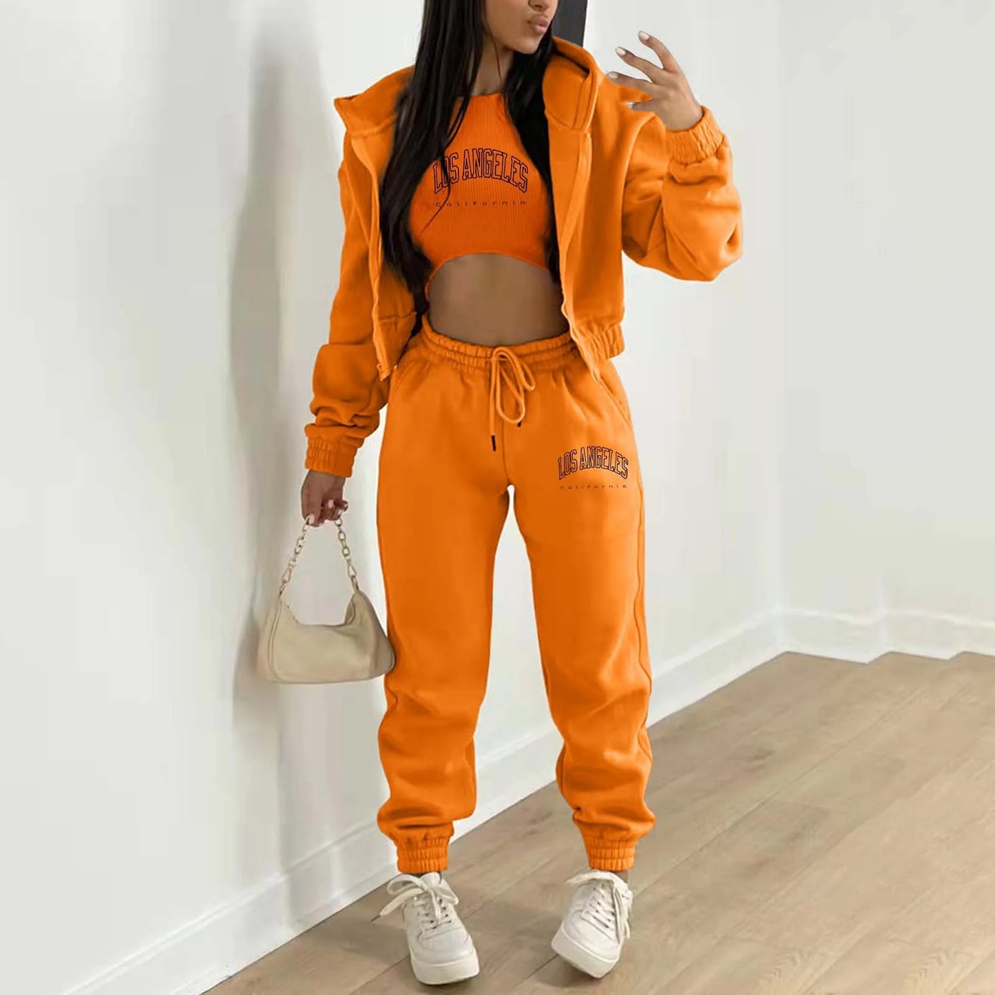 Orange plush knit sweater set with Los Angeles letter print, hoodie, and relaxed joggers for lounging.