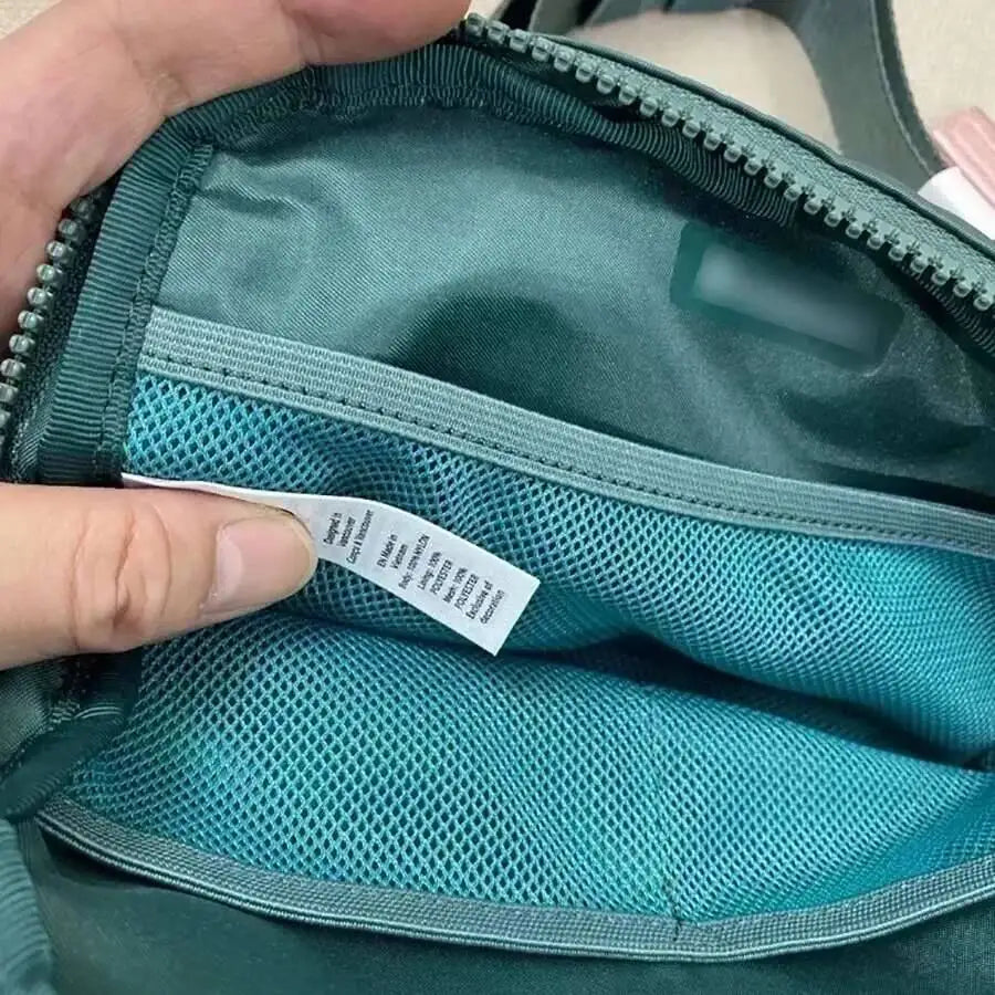 Teal crossbody bag with interior mesh pockets, zip closure, and adjustable strap for hands-free running.