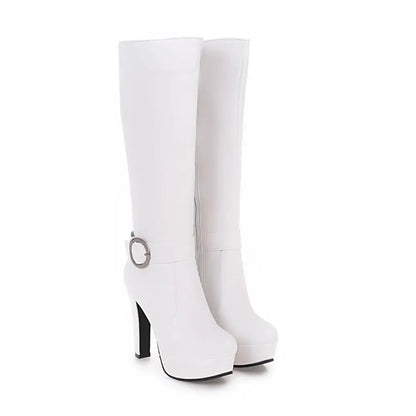 White faux leather knee-high platform boots with high heels, side zippers, and ankle strap with round buckle.