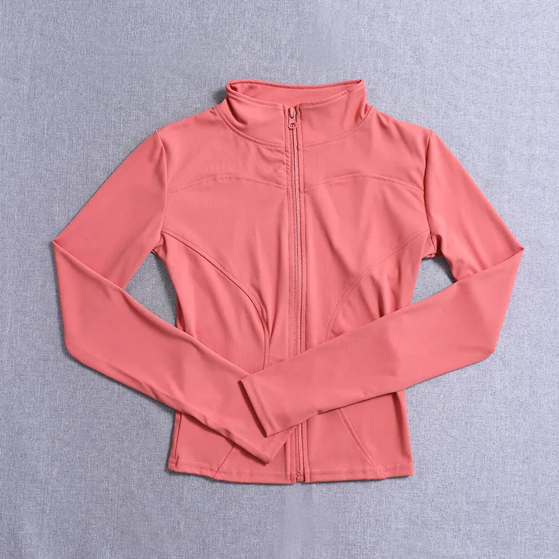 Coral pink fitted long sleeve jacket with a front zip and seams for gym training or yoga.