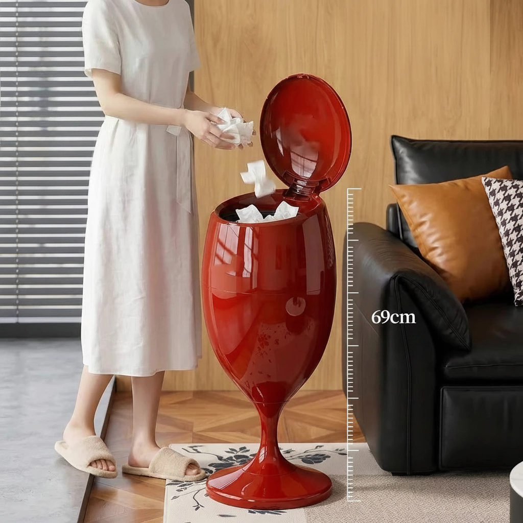 Glossy red wine glass-shaped trash can with open press lid, standing 69cm tall in a living room.