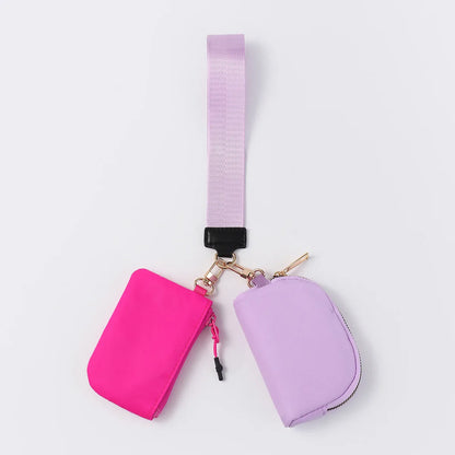Pink and lavender nylon zip closure wristlet wallet with dual pouches and an adjustable strap for daily errands.