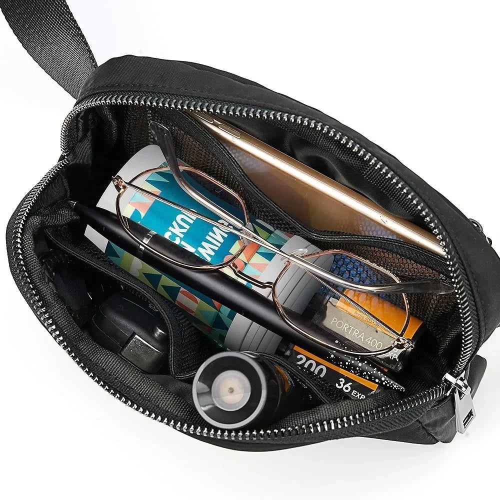 Black multi-pocket crossbody bag with zip closure and adjustable strap, organized for running and yoga essentials.