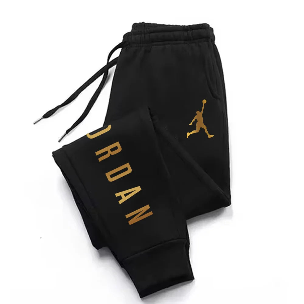 Black midweight joggers with gold letter print and drawstring waist, fitted for athletic training.