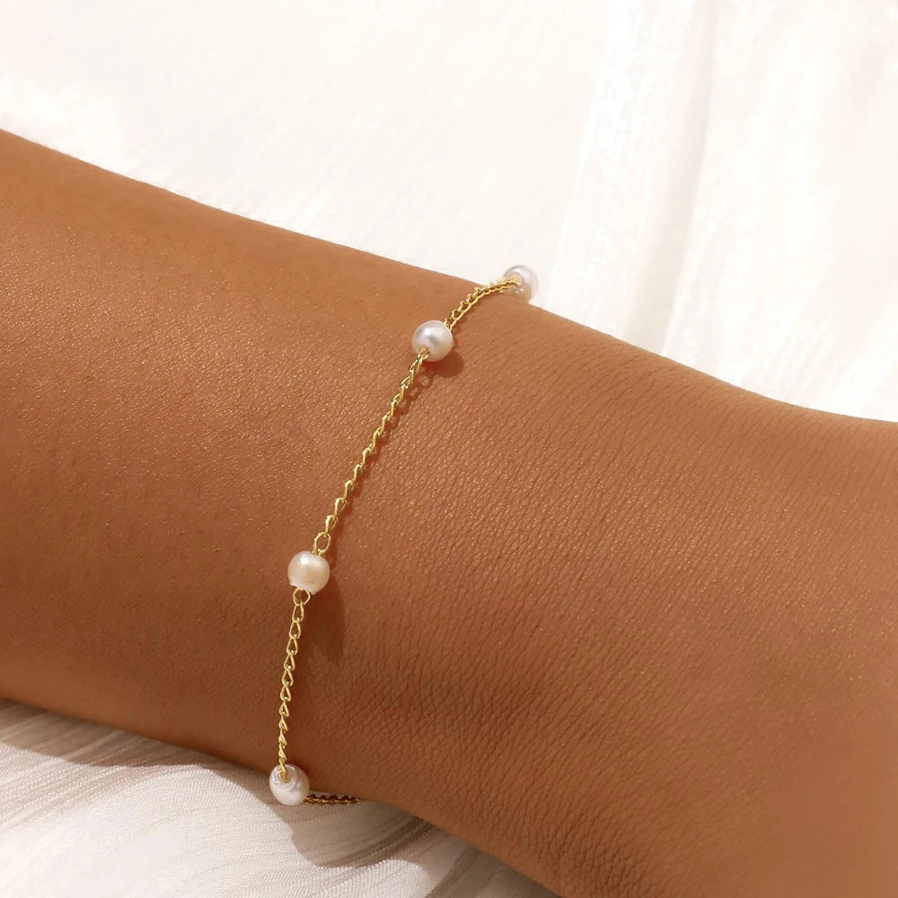 Women's pearl bracelet with heart and evil eye charms