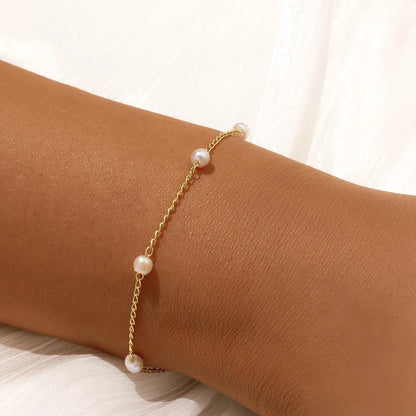 Women's pearl bracelet with heart and evil eye charms