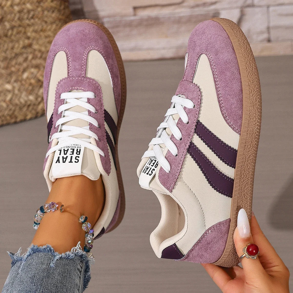 Purple and beige leather slip-on sneakers with gum soles and white laces for comfortable casual wear.