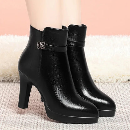 Black leather ankle boots with block heels, platforms, and a decorative buckle strap.
