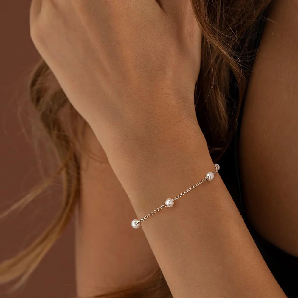 Women's pearl bracelet with heart and evil eye charms