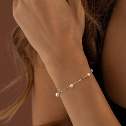 Women's pearl bracelet with heart and evil eye charms