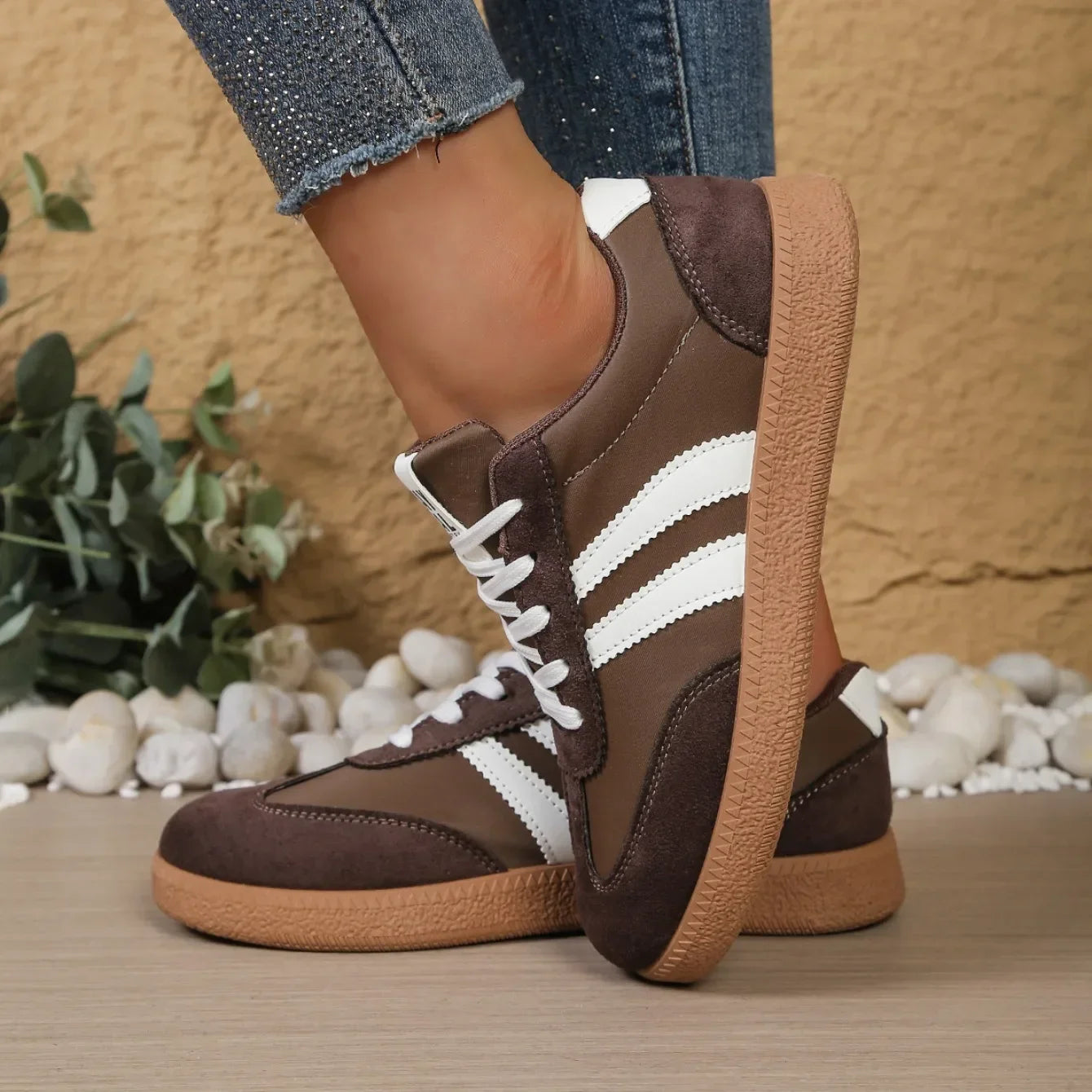 Brown leather and suede sneakers with white stripes and gum soles, slip-on shoes for casual daily wear.
