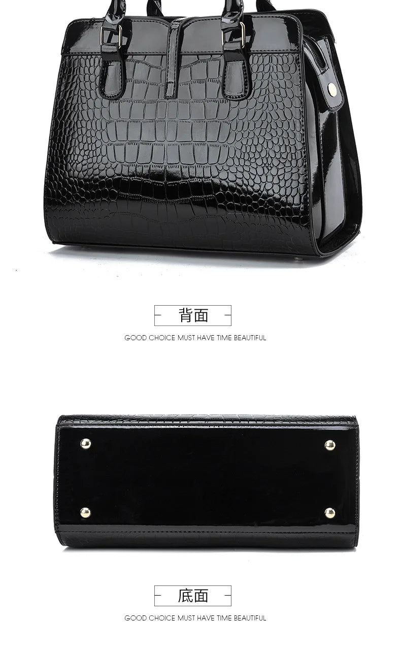 Black patent leather handbag with crocodile pattern, dual top handles, and four protective feet on the base.