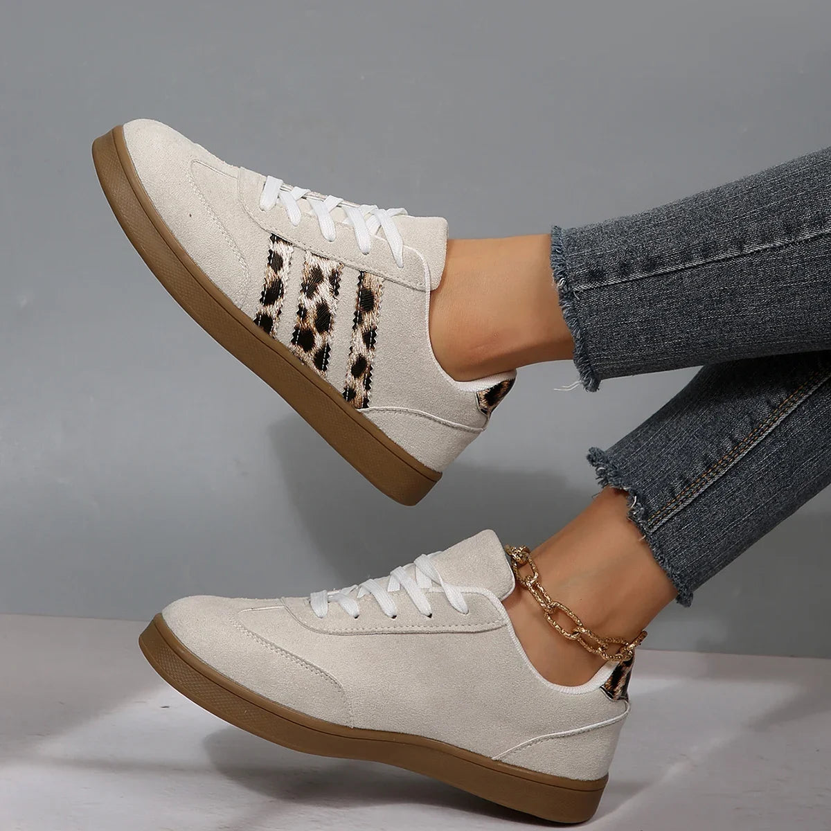 Off-white suede sneakers with leopard print stripes and brown soles, slip-on footwear for comfortable daily wear.