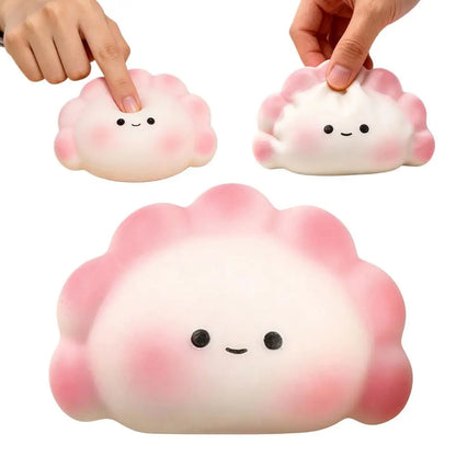 Soft white and pink dumpling squishy fidget toy with a cute face, used as a portable stress relief squeeze toy.