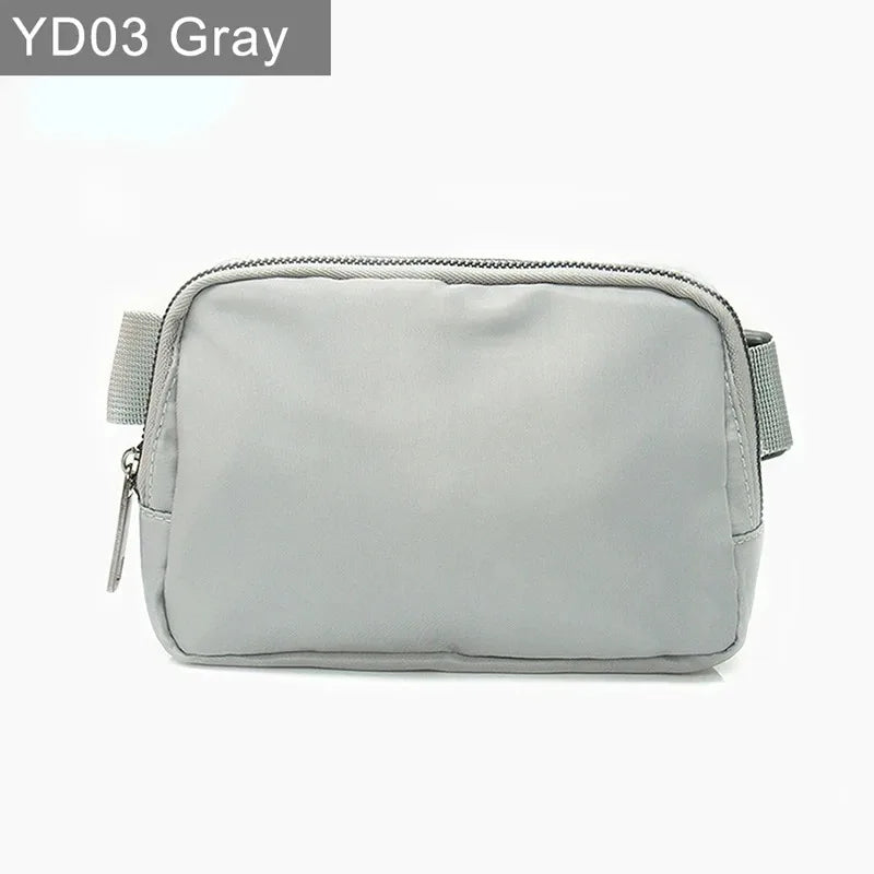 Gray waterproof crossbody bag with zip closure and adjustable strap for running and yoga.