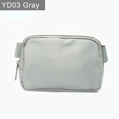 Gray waterproof crossbody bag with zip closure and adjustable strap for running and yoga.