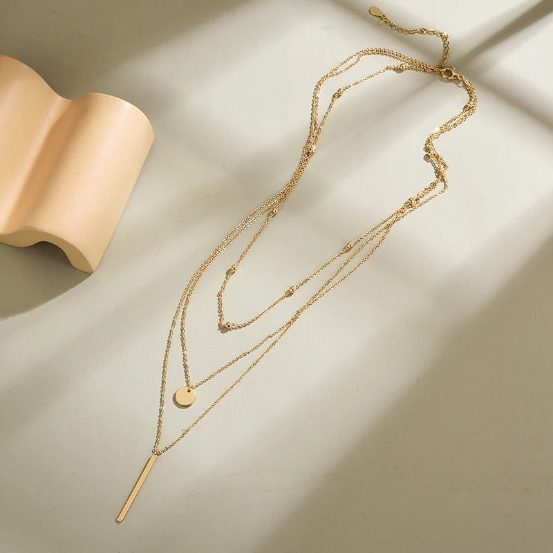 Women's gold-tone layered chain necklace with pendant detail