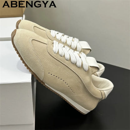 Beige suede casual sneakers with white laces, white collars, and brown rubber outsoles.