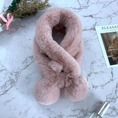 Dusty pink plush faux-fur cross scarf with two large pom-pom ends.