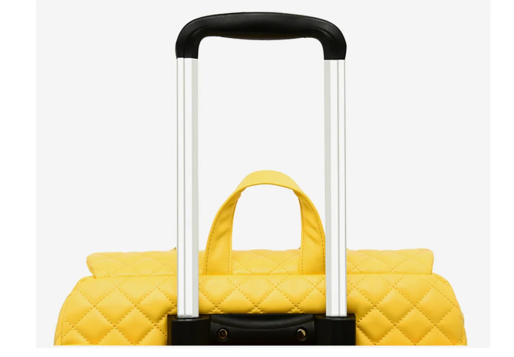 Yellow quilted travel bag with a black and silver retractable handle and top carry strap.