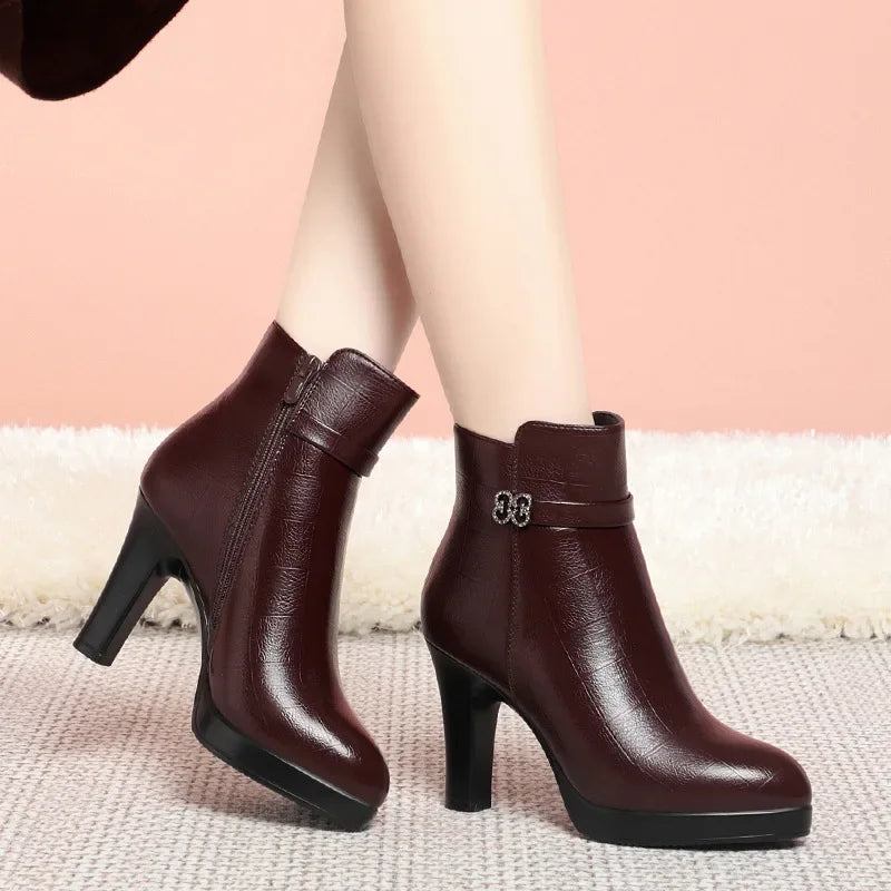 Burgundy faux-leather ankle boots with high block heels, side zippers, and decorative rhinestone side buckles.