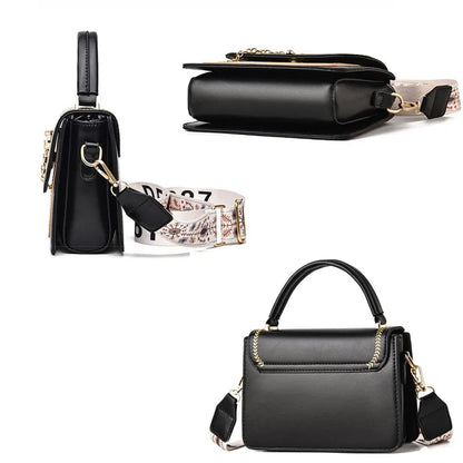 Black leather shoulder bag with top handle and patterned strap with gold-tone hardware.