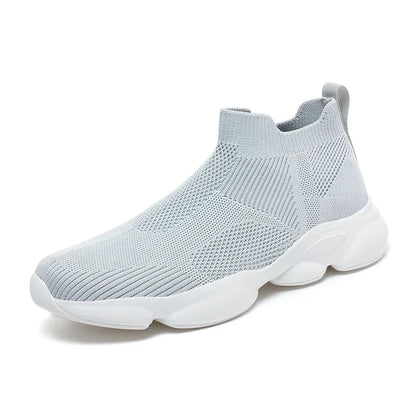 Light grey knit slip-on sneaker with thick white sole and breathable design for casual wear.