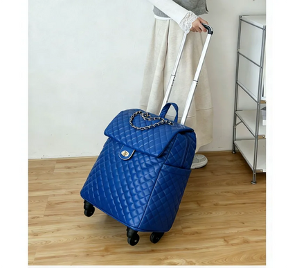 Blue quilted faux leather rolling travel bag with a flap closure, chain accent, and telescopic handle.