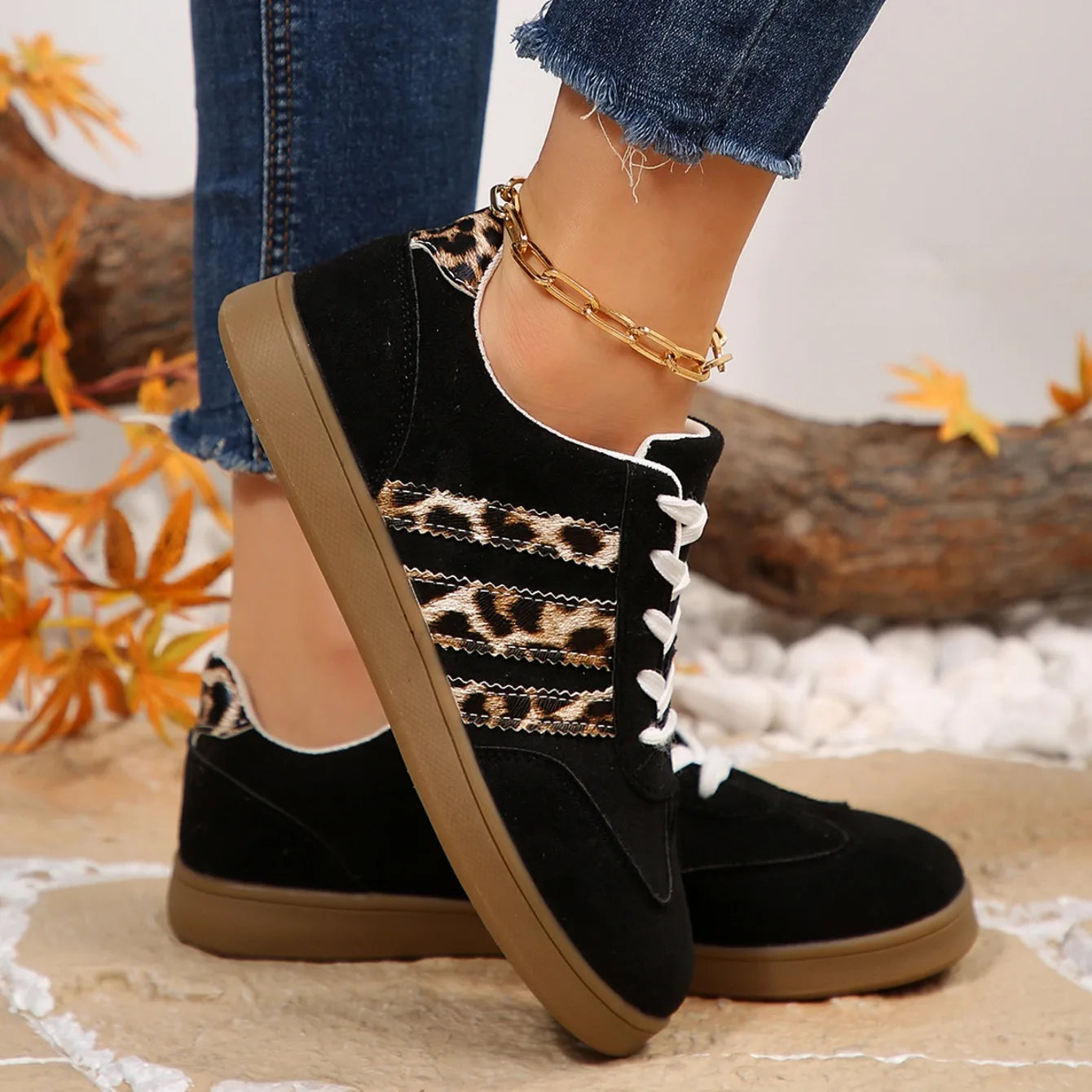 Black suede slip-on sneakers with brown soles, leopard print side stripes, and cushioned insoles for outdoor walking.