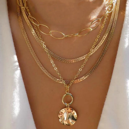 Layered necklace set featuring multi-strand chains and a textured round pendant