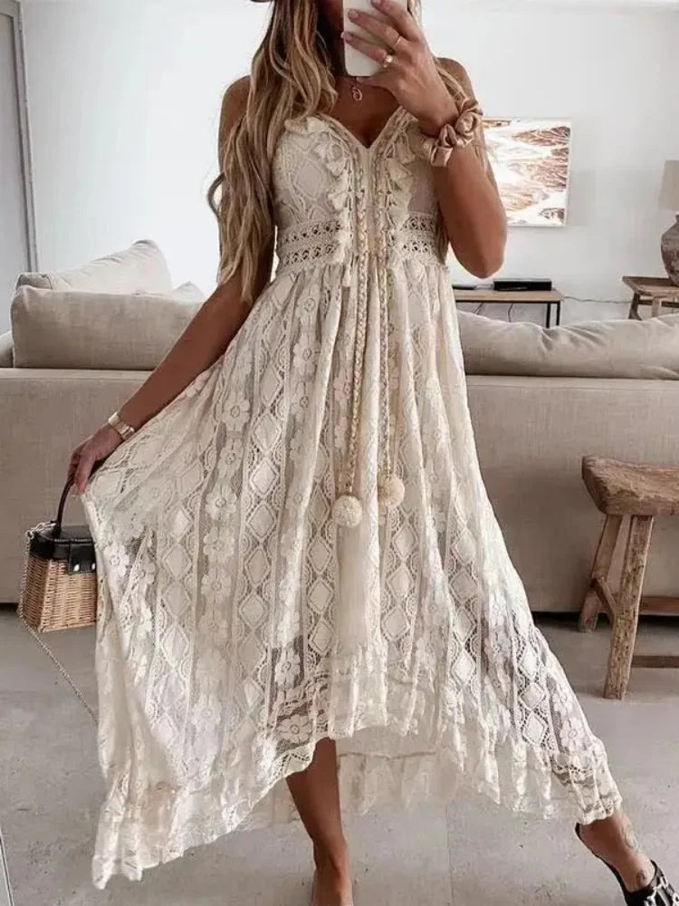 White lace sleeveless dress with V-neck, flowy skirt, and tassel detail for beach vacation.