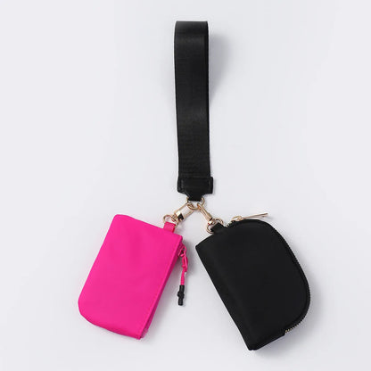 Pink and black nylon dual pouch wristlet wallet with a zip closure for carrying daily essentials.