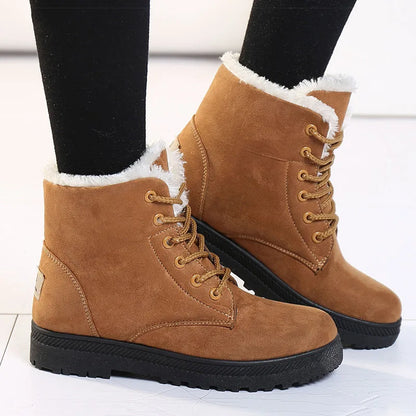 Tan suede ankle boots with lace-up front, thick black soles, and white faux-fur lining.