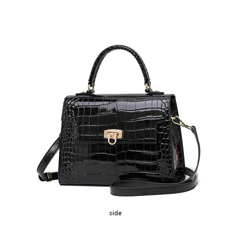 Black patent leather handbag with crocodile pattern, top handle, flap closure, and a crossbody strap.