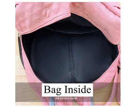 Open interior of a quilted pink rolling travel backpack, showing black fabric lining and a pocket.