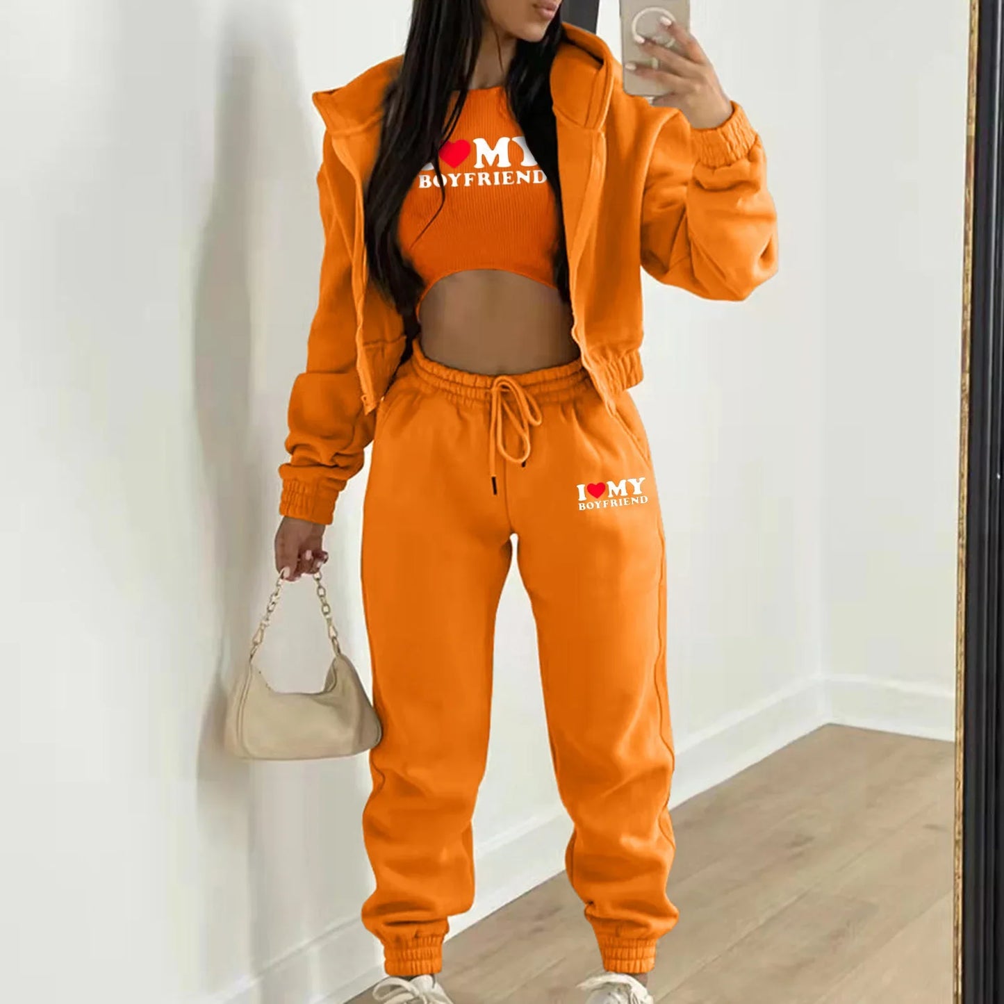 Orange knit hooded sweater set with letter print, relaxed fit, and drawstring joggers for a casual lounge outfit.
