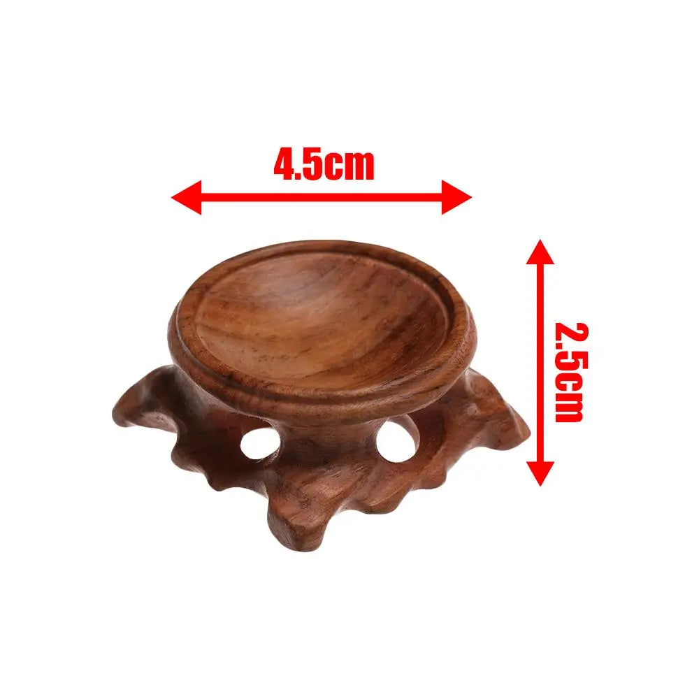 Brown wooden crystal ball stand with a carved round base, 4.5cm wide and 2.5cm tall.