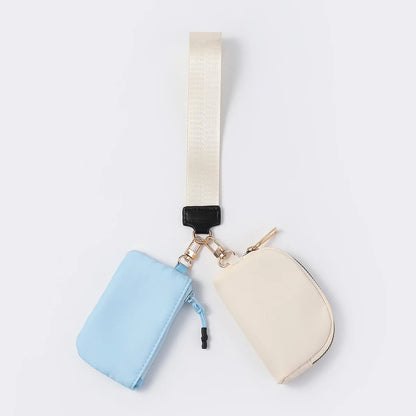 Blue and cream waterproof wristlet wallet with zip closure pouches for carrying everyday essentials.