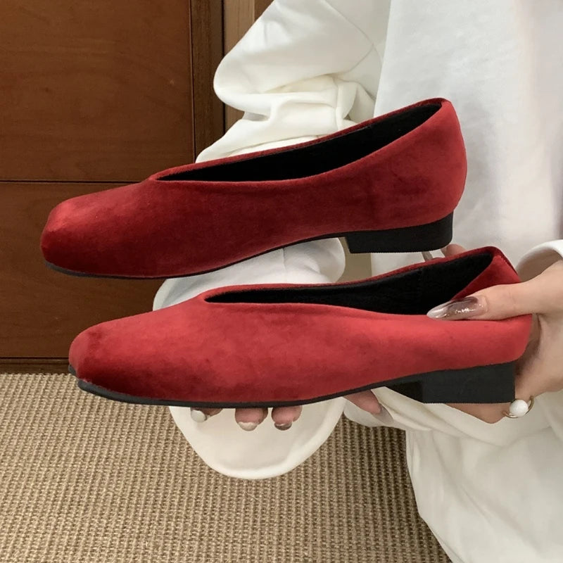 Red suede square toe slip-on flats with black soles for cushioned everyday wear.
