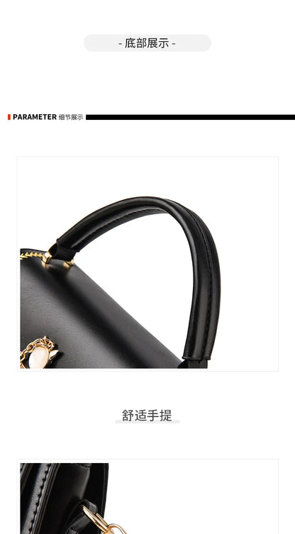 Black leather handbag handle detail with gold hardware and stitching.