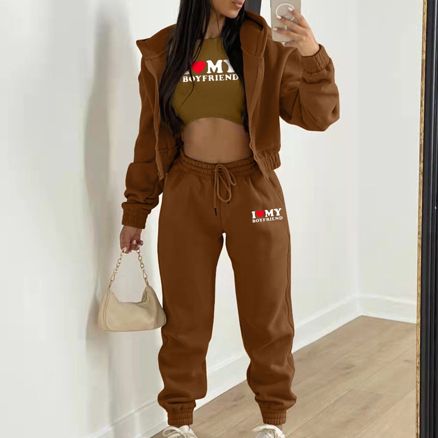 Brown knit hoodie, crop top, and high waist joggers with letter print for a relaxed loungewear look.