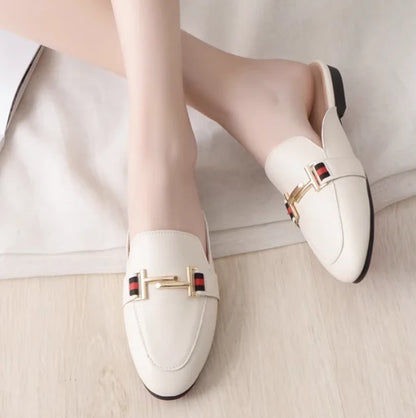 Off-white slip-on mules with a gold metal chain and red and black striped accents for casual outdoor wear.