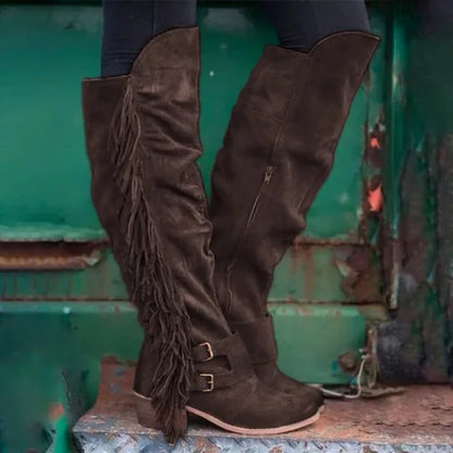 Dark brown suede over-the-knee boots with side fringe, double ankle buckle straps, and thick heels.